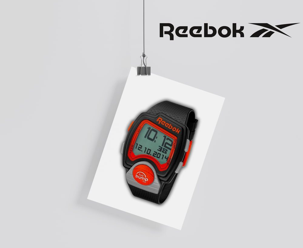 branding und design portfolio für Reebok – sportliche Digitaluhr in Schwarz-Rot auf aufgehängtem Poster, fokussierter Markenauftritt.